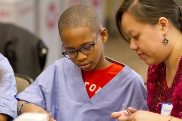 A UMN Medical Professor works with a young student