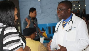 Kola Okuyemi speaks with a patient